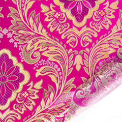 Decorative fabric with gold and purple floral pattern on a pink background