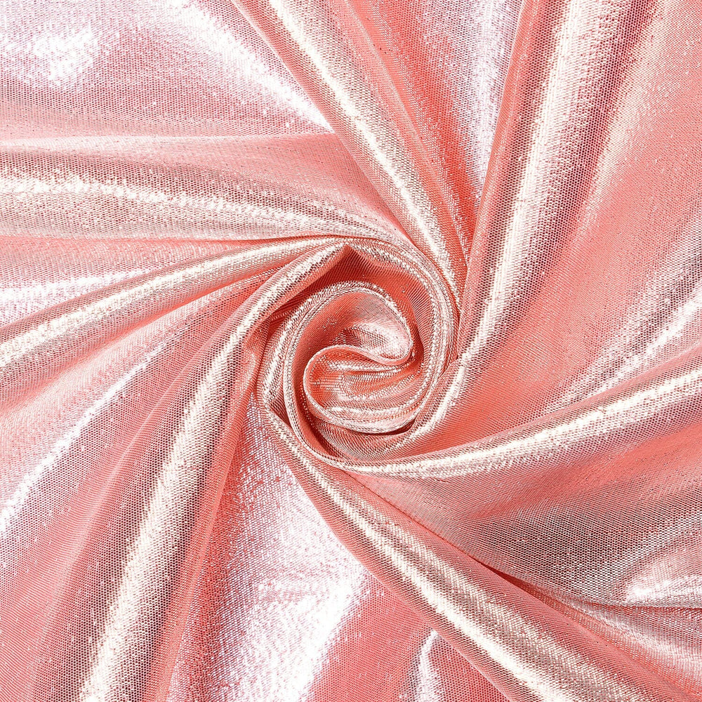 A swirled piece of petal pink tissue lame fabric, displaying a metallic sheen.