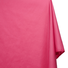 Close-up of bright pink fabric with a slight texture on a white background