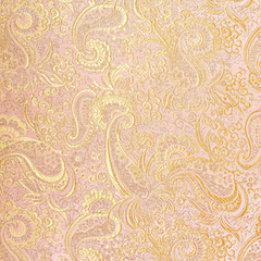 Close-up of peach and gold paisley brocade fabric showing intricate patterns.
