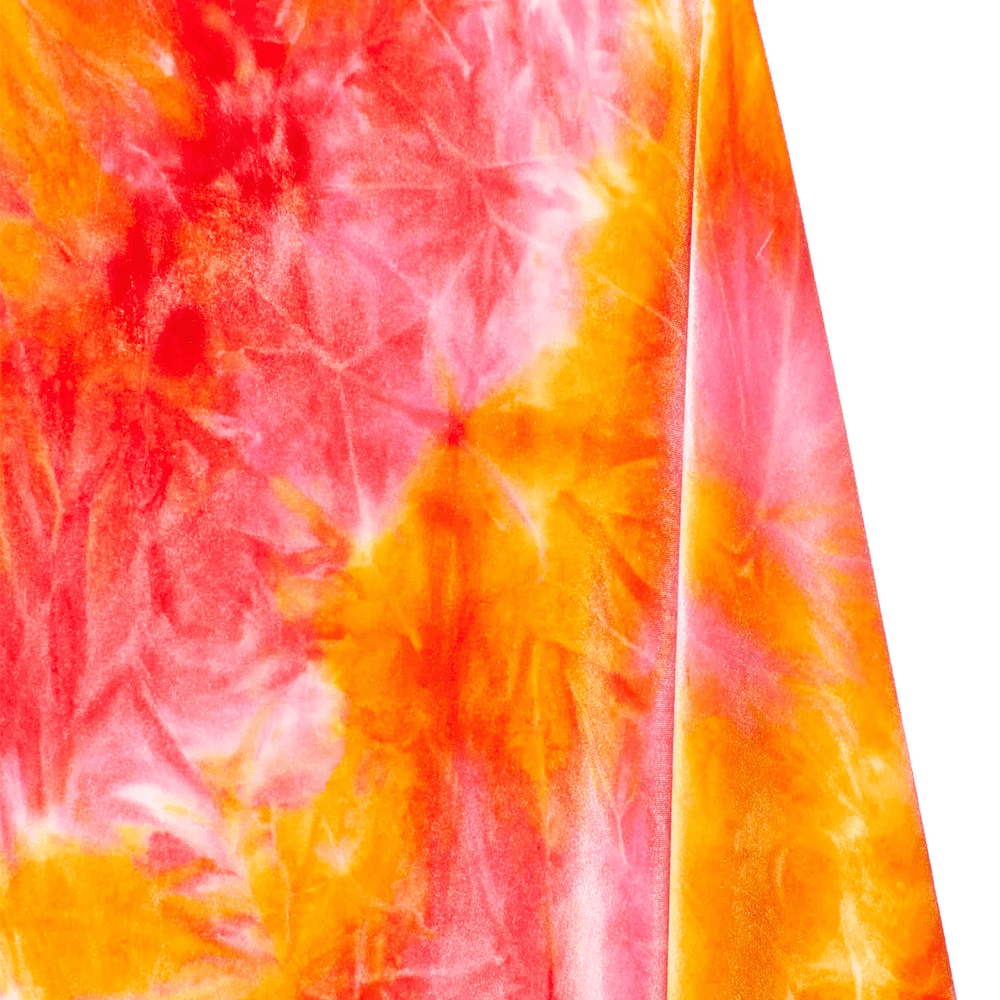 Close-up of a tie-dye fabric with orange and pink patterns on a white background