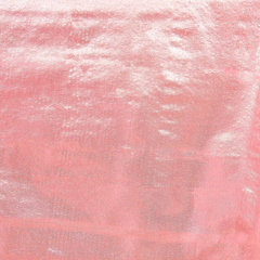 Close-up of a pink metallic fabric with a subtle textured pattern, reflecting light.