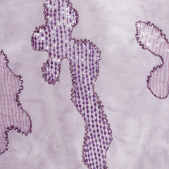 Close-up of a lilac-colored georgette fabric with abstract beaded sequins pattern