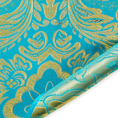Close-up of turquoise fabric with gold floral patterns