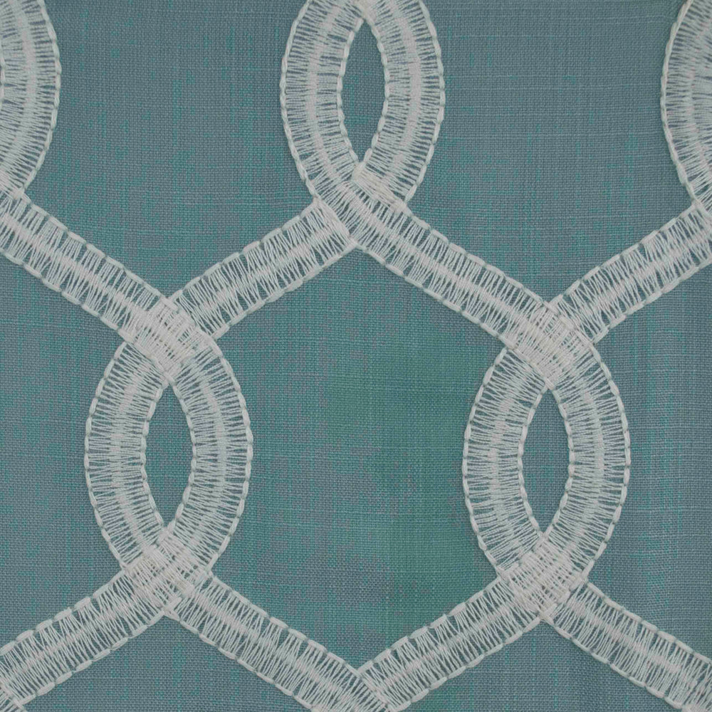 Close-up of fabric with a geometric pattern featuring blue, green, and white embroidery | Sold by Beautiful Windows Elgin