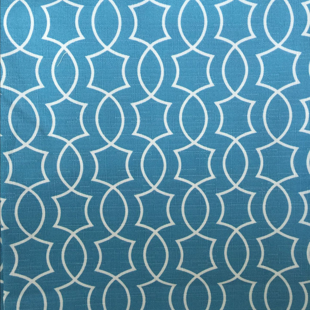 A close-up image of a blue fabric with a white geometric pattern.