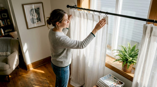 Woman adjusting sheer curtains showing heading