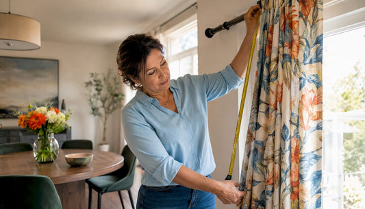 Woman measuring curtain rod length indoors