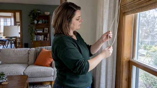 Homeowner inspecting a looped drapery cord