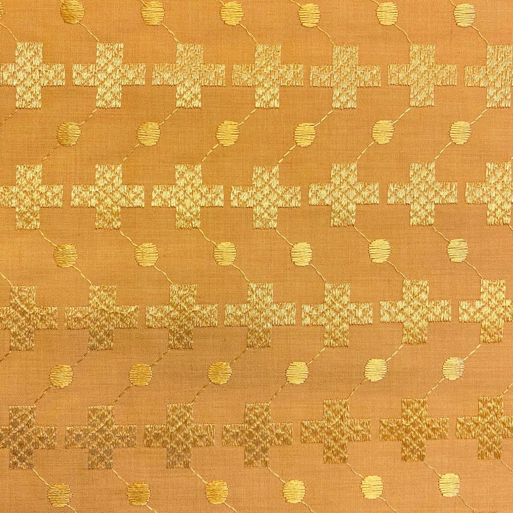 Patterned fabric with gold crosses and dots on a brown background