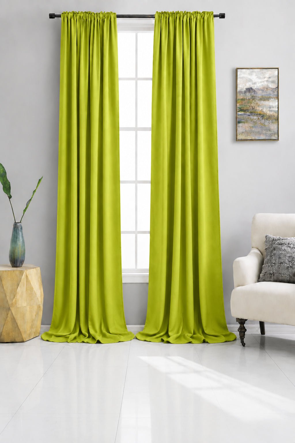 Beige curtains hanging in a living room with a couch and side table.