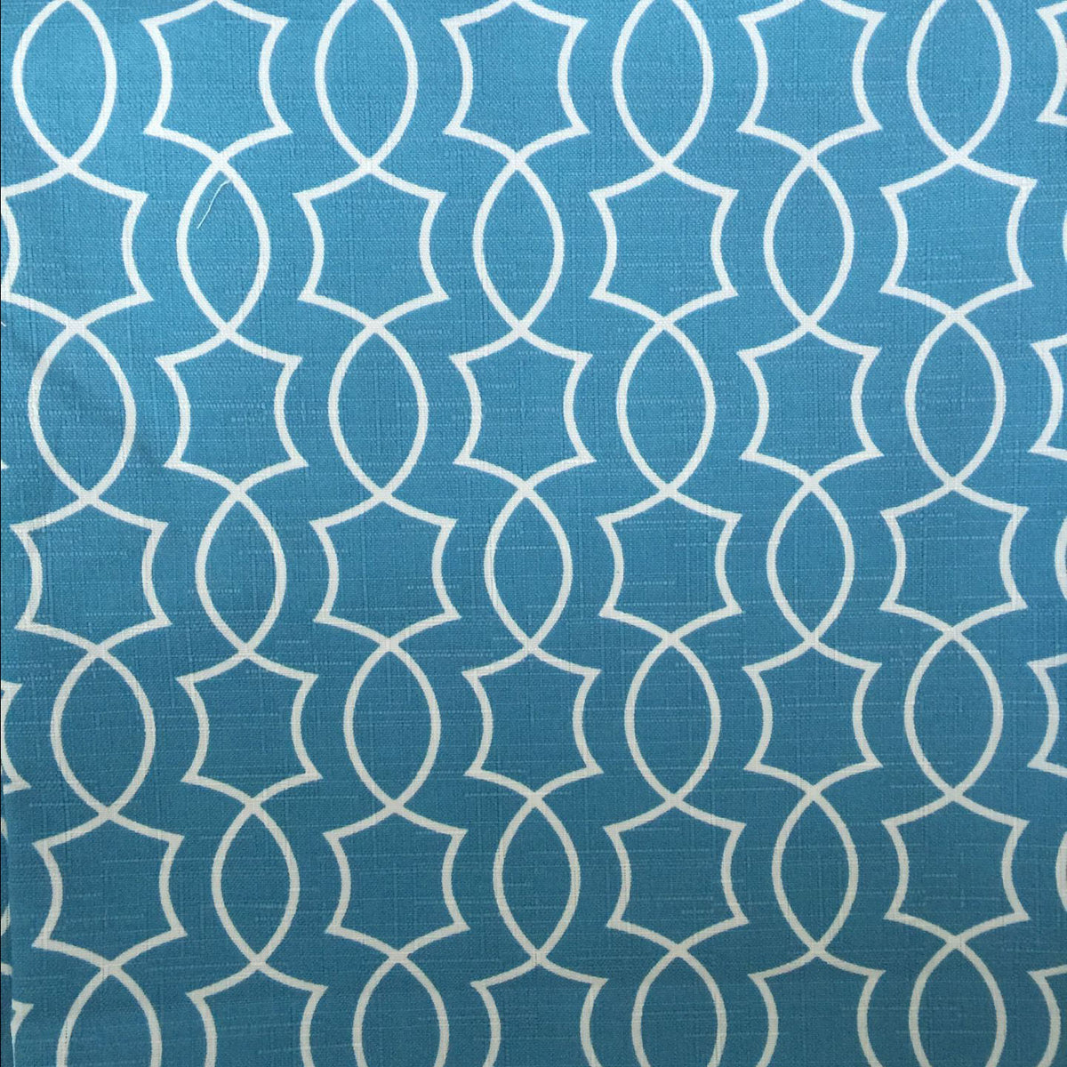 A close-up image of a blue fabric with a white geometric pattern.