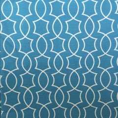 A close-up image of a blue fabric with a white geometric pattern.